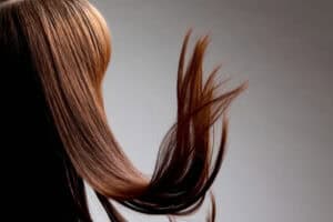 Na zdjęciu są przedstawione brązowe, lśniące włosy.